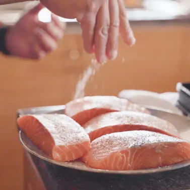 Raw salmons being seasoned