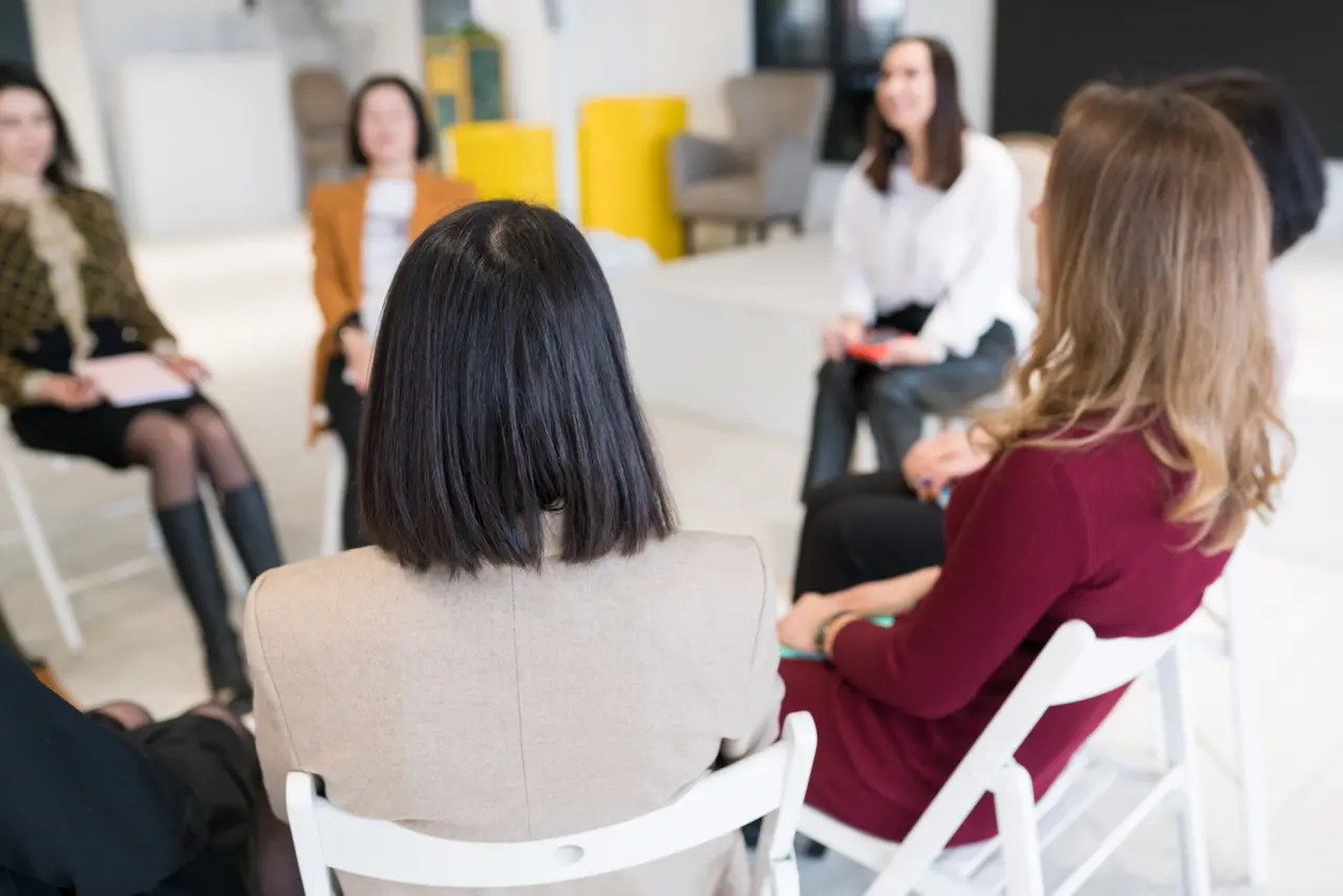 People sitting in a circle in a group therapy session