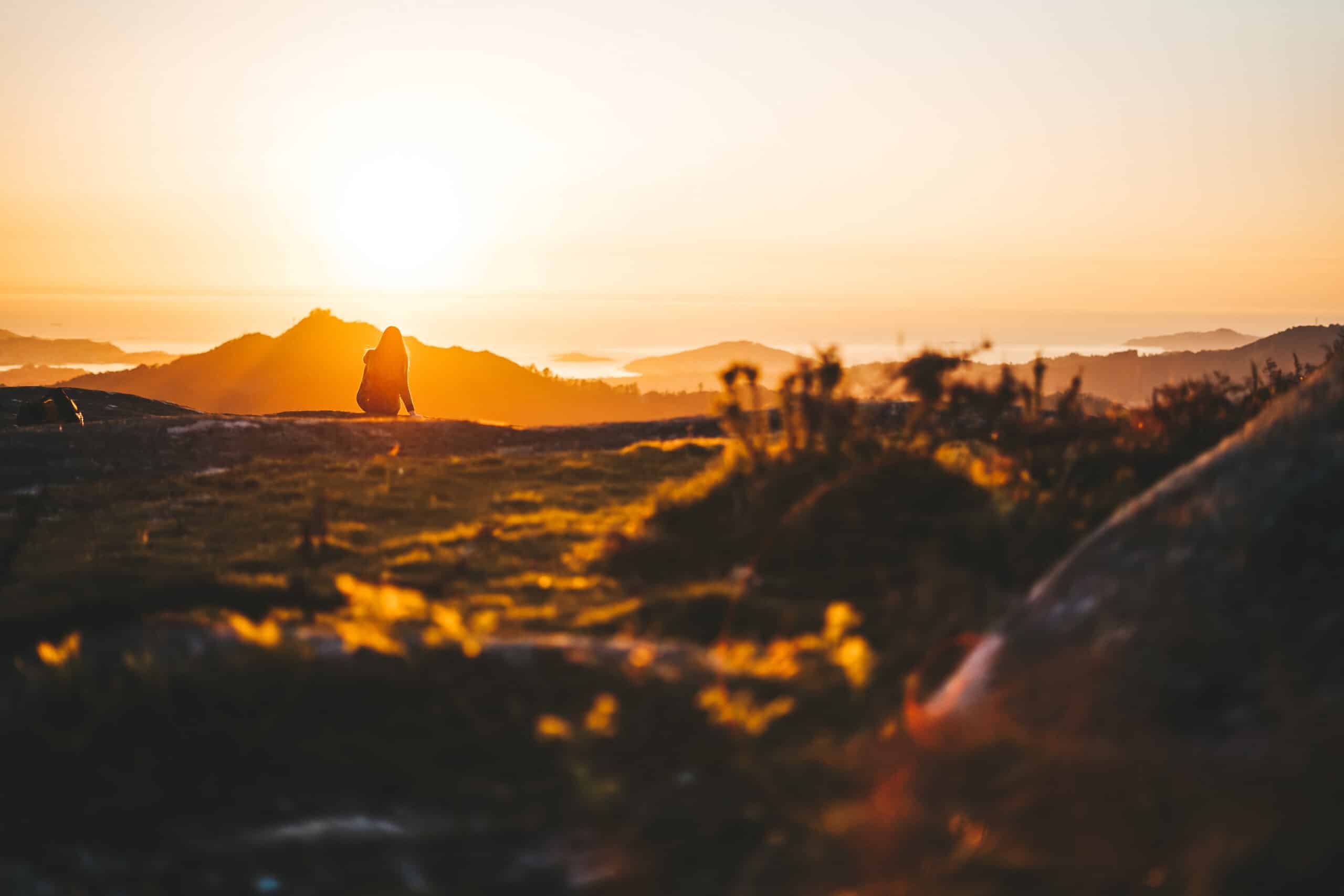 Young woman contemplating the sunset from Mount Galiñeiro in Vigo, Galicia, Spain